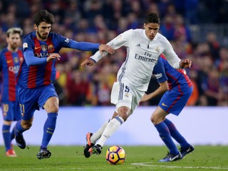 Raphael Varane (v bielom) v súboji s Andrém Gomesom.