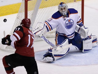 Brankár Edmontonu Cam Talbot zasahuje pri šanci Radima Vrbatu z Arizony. 