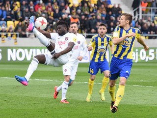 Pred hráčom Dunajskej Stredy Tomášom Hukom (vpravo) odkopáva loptu Robert Tambe z Trnavy.