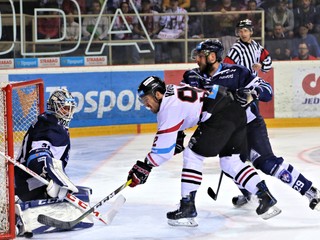 Brock Higgs (v strede v bielom) z Banskej Bystrice sa pokúša pretlačiť puk za chrbát brankára Mathieuho Corbeila.