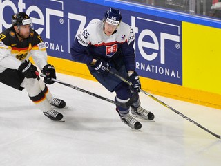 Slovenský obranca Michal Čajkovský (vpravo) korčuľuje s pukom na hokejke, bráni ho Nemec Marcus Kink.