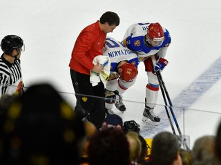 Ruský hokejista Sergej Mozjakin odchádza za pomoci lekára a svojho spoluhráča z ľadovej plochy.