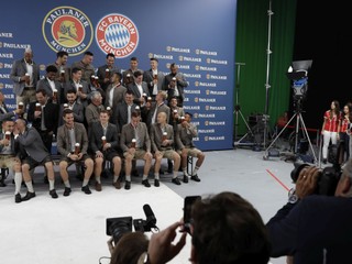 Futbalisti Bayernu Mníchov v tradičnom bavorskom oblečení počas fotenia pre spoločnosť na výrobu piva.