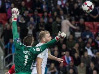 Adam Nemec sa snaží zasiahnuť loptu hlavičkou vo vzdušnom súboji s brankárom Hoggom.