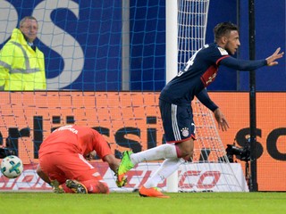 Na snímke vpravo hráč Bayernu Corentin Tolisso oslavuje víťazný gól, vľavo pekonaný brankár Hamburgu Christian Mathenia.