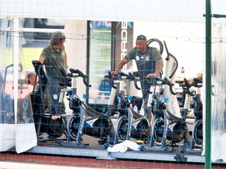 Ľahko zranený nemecký futbalista Jerome Boateng sa zahrieva na bicykli , vľavo sa pozerá lekár nemeckého futbalového tímu Hans-Wilhelm Müller-Wohlfahrt, archívna snímka.