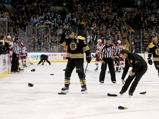 Usporiadatelia odpratávajú čiapky z ľadu po tom, ako Patrice Bergeron strelil svoj tretí gól v zápase.