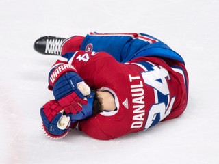 Hokejista Montrealu Canadiens Phillip Danault leží na ľade po tom, čo ho slovenský obranca v drese Bostonu Bruins Zdeno Chára nešťastne trafil strelou od modrej čiary do hlavy.