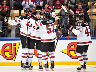 Kanadskí hokejisti sa radujú po jednom z gólov.