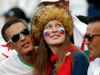 Ruská fanúšička a alžírski fanúšikovia počas zápasu MS vo futbale 2014 Alžírsko - Rusko na štadióne Arena da Baixada v brazílskej Curitibe.
