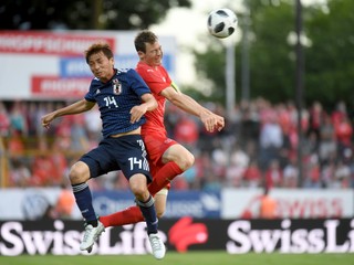 Stephan Lichtsteiner (vpravo) zvádza hlavičkový súboj s Japoncom Takashim Inuim.