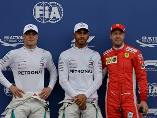 Pred objektívmi fotografov pózujú traja najlepší zo sobotňajšej kvalifikácie - zľava druhý Valtteri Bottas, prvý Lewis Hamilton a tretí Sebastian Vettel.