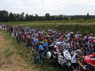 Cyklisti čakajú na ceste po tom, čo 16. etapu Tour de France 2018 prerušil štrajk farmárov.