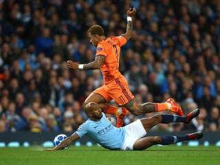 Hráč Manchesteru City Fabian Delph (dole) padá v súboji s Memphisom Depayom z Lyonu vo futbalovom zápase F-skupiny Manchester City - Olympique Lyon 1. kola Liga majstrov na štadióne v Manchesteri.