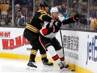 Kapitán Bostonu Bruins Zdeno Chára (vľavo) v súboji s Bradym Tkachukom z Ottawy.