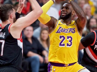 LeBron James (vpravo) sa pokúša zamieriť na kôš cez brániaceho Jusufa Nurkiča z Portlandu.