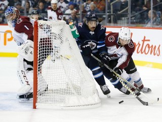 Mathieu Perreault (v strede) z Winnipegu obieha s pukom bránku bránený Alexandrom Kerfootom z Colorada.