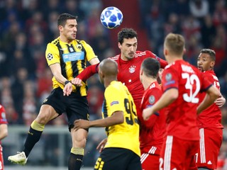 Hráč AEK Atény Vasileios Lampropoulos a Mats Hummels z Bayernu v hlavičkovom súboji.