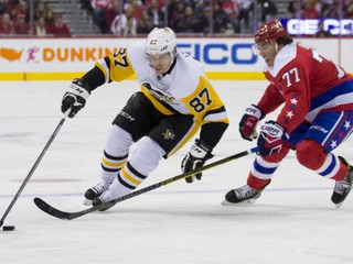 Sidney Crosby s pukom, bráni ho protihráč T.J. Oshie v červenom drese Capitals.