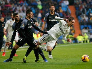 Luka Modrič je faulovaný hráčmi FC Sevilla.