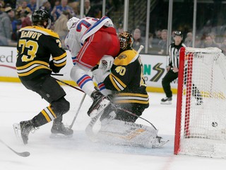 Moment, keď útočník New Yorku Rangers Filip Chytil vrazil do brankára Bostonu Bruins Tuukka Raska (vpravo).