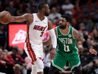 Dwyane Wade (vľavo) z Miami Heat pred brániacim Kyrieom Irvingom z Bostonu Celtics.