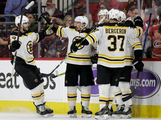 Hokejisti Bostonu Bruins oslavujú gól v zápase proti Caroline Hurricanes.