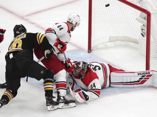 Na snímke vľavo švédsky útočník Bostonu Marcus Johansson strieľa gól, dole český brankár Petr Mrázek v prvom zápase finále 3. kola play off Východnej konferencie hokejovej NHL Boston Bruins - Carolina Hurricanes (5:2) v noci na 10. mája 2019.