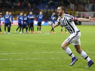 Leonardo Bonucci (vpravo) premenil rozhodujúci pokutový kop, v pozadí hráči Interu Miláno smútia.