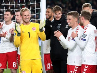 Dánsky brankár Kasper Schmeichel (druhý zľava) oslavuje so spoluhráčmi na ihrisku po postupe na ME na konci zápasu D-skupiny Írsko - Dánsko.