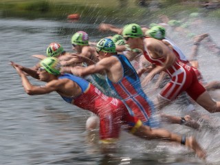 Triatlonisti skáču do vody počas plaveckej časti na šiestom podujatí Svetovej série ITU v kanadskom Edmontone 29. júla 2017. 