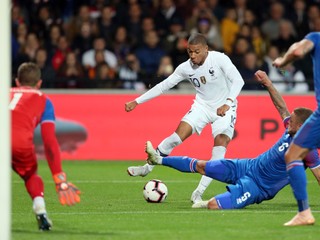 Kylian Mbappé(uprostred) kope do lopty cez Ragnara Sigurdssona z Islandu v prípravnom futbalovom zápase Francúzsko - Island v Guingampe 11. októbra 2018. 