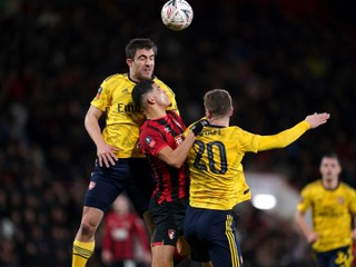 Sokratis Papastathopoulos (vľavo) a Shkodran Mustafi (vpravo) bojujú o loptu s Dominicom Solankem v zápase AFC Bournemout - Arsenal FC.