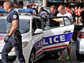 Policajt vedie zatknutého ruského fanúšika pred zápasom na Euro 2016 - archívna fotografia.