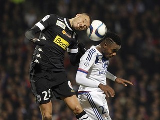 V hlavičkovom súboji bojujú o loptu hráč Angers Romain Saiss (vľavo) a Gnaly Albert Maxwell Cornet z Lyonu.