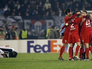 Je koniec. Futbalisti Augsburgu oslavujú postup, hráč domáceho Partizanu smúti nad premárnenou šancou.