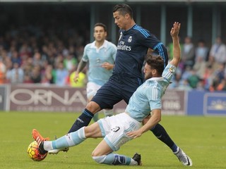 Sergio Gomez zo Celty Vigo (vpravo) sa sklzom pokúša vypichnúť loptu Cristianovi Ronaldovi.