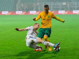 Futbalisti Ružomberka v pohárovom zápase odčinili víkendovú ligovú prehru zo Žiliny. Jeden z gólov do siete Topoľčian strelil aj Peter Maslo (v bielom). Na snímke vypichuje loptu hráčovi MŠK Žilina Lukášovi Jánošíkovi.