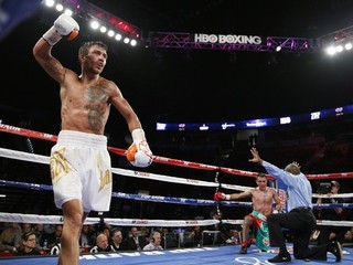 Ukrajinec Vasiľ Lomačenko (vľavo) sa teší z úspešnej obhajoby titulu profesionálnej verzie WBO v perovej hmotnostnej kategórii po víťazstve nad Mexičanom Romulom Koasichom.