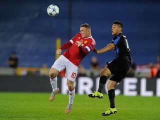 Wayne Rooney (vľavo) hlavičkuje loptu pred hráčom Clubu Bruggy Óscarom Duartem.