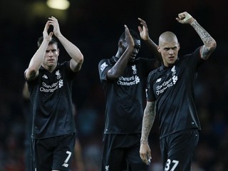 Futbalisti Liverpoolu v menej tradičných čiernych dresoch mávajú svojim fanúšikom po bezgólovej remíze s Arsenalom Londýn.