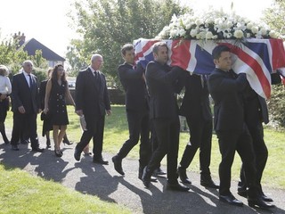 Nosiči nesú rakvu s pozostatkami zosnulého britského jazdca Justina Wilsona počas pohrebu v Paulerspury.