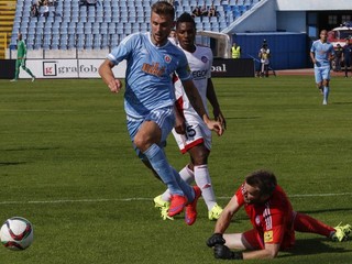 Brankár Trenčína Igor Šemrinec (vpravo) zasahuje pri šanci hráča Slovana Tamása Priskina.