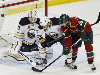 Brankár Buffala Sabres Chad Johnson (vľavo) inkasuje gól v stretnutí proti Minnesote. Pred jeho bránou cloní Jason Pominville (vpravo), bráni ho Phil Varone.