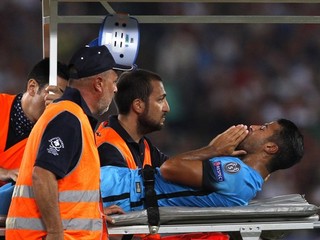 Zraneného futbalistu Barcelony Rafinhu odnášajú na nosidlách z ihriska v zápase Ligy majstrov v Ríme.