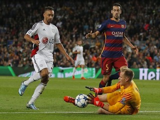 Brankár FC Barcelona Marc-André ter Stegen chytá loptu pred dobiehajúcim Karimom Bellarabim (vľavo) z Bayeru Leverkusen.