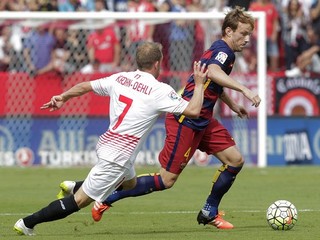 Hráč Barcelony Ivan Rakitič (vpravo) obchádza s loptou Michaela Krohna-Dehliho z FC Sevilla.