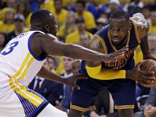 LeBron James (vpravo) sa v zápase finále NBA snaží uvoľniť cez brániaceho Draymonda Greena z Golden State.