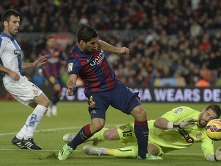Kiko Casilla (vpravo) sa snaží chytiť loptu pred dobiehajúcim Luisom Suárezom z FC Barcelona.