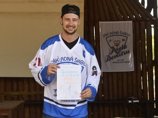 Tomáš Tatar pózuje so symbolickým vysvedčením za 1. až 9. ročník, ktoré si prevzal počas slávnostného ukončenia školského roka na ZŠ Pavla Demitru 30. júna 2015 v Dubnici nad Váhom. Tatar ako bývalý žiak túto školu v minulosti podporil hokejovým výstrojom